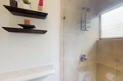 a bathroom with a shower with a glass door at The Cove 9/10 in Ocotal