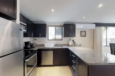 a kitchen with black cabinets and a white refrigerator at The Cove 9/10 in Ocotal