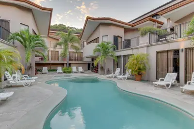 a swimming pool in the courtyard of a building with a resort at The Cove 9/10 in Ocotal