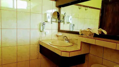a bathroom with a sink and a mirror at Volcano Lodge, Hotel & Thermal Experience in Fortuna