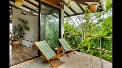 two chairs on a porch with a view of the forest at Private Home in Montezuma with Ocean View in Montezuma