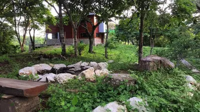a garden with rocks and a bench in front of a house at Private Home in Montezuma with Ocean View in Montezuma
