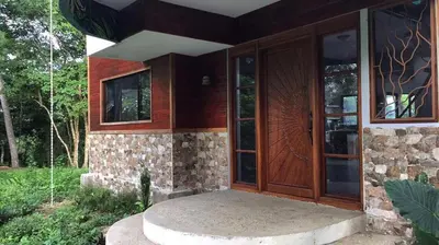 a house with wooden doors and a stone wall at Private Home in Montezuma with Ocean View in Montezuma