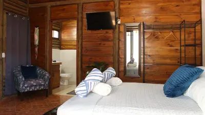 a bedroom with a bed with blue and white pillows at Bungalows Ballena in Uvita