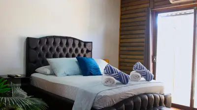 a bedroom with a bed with towels on it at Bungalows Ballena in Uvita