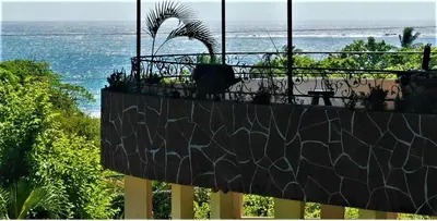 a balcony with a view of the beach and the ocean at Casa La Guaria in Sámara