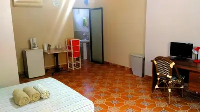 a bedroom with a bed and a desk and a computer at Casa La Guaria in Sámara