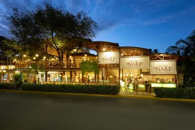 a large building with people standing outside at night at Hotel Tamarindo Diria Beach Resort in Tamarindo