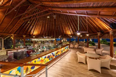 a restaurant with a bar and tables and chairs at Hotel Tamarindo Diria Beach Resort in Tamarindo