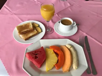 a table with a plate of toast and a cup of coffee at Park Hotel in Puerto Limón