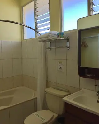 a bathroom with a toilet and a tub and a sink at Park Hotel in Puerto Limón