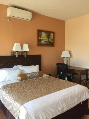 a hotel room with a bed and a desk and two lamps at Park Hotel in Puerto Limón