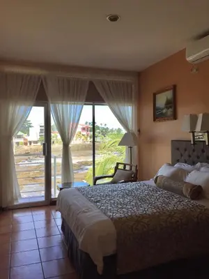 a bedroom with a large bed and a large window at Park Hotel in Puerto Limón