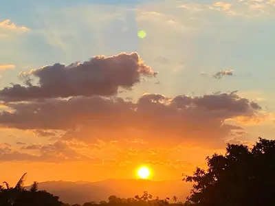 a sunset with the sun in the sky at Hotel Vista Linda Montaña in Alajuela City