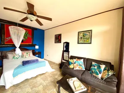 a living room with a couch and a ceiling fan at Hotel Vista Linda Montaña in Alajuela City