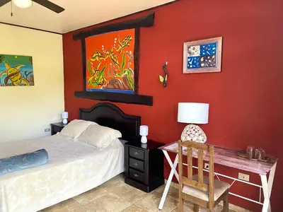 a bedroom with a bed and a desk with a chair at Hotel Vista Linda Montaña in Alajuela City