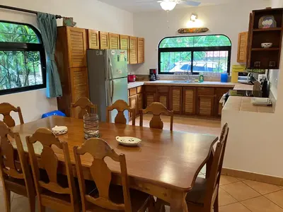 a kitchen with a wooden table and a refrigerator at Villa Tortuga in Nosara