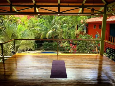 a room with a wooden floor and a purple yoga mat at Villa Tortuga in Nosara