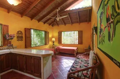 a kitchen with a living room with a couch and a table at La Palapa Ecolodge in Portalón