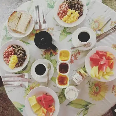a table with plates of food and bowls of fruit at La Palapa Ecolodge in Portalón