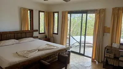 a bedroom with a bed and a sliding glass door at Finca Los Caballos Montezuma in Montezuma