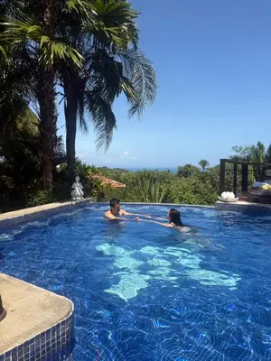 two people are swimming in a swimming pool at Finca Los Caballos Montezuma in Montezuma