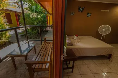 a room with a bed and a balcony with a fan at Hotel El Icaco Tortuguero in Tortuguero