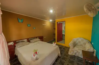 a bedroom with a bed and butterflies on the wall at Hotel El Icaco Tortuguero in Tortuguero