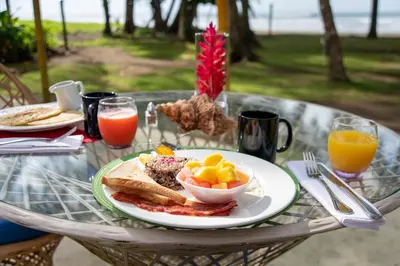 a table with a plate of breakfast food on it at Alma del Pacifico Hotel & Spa in Esterillos Este