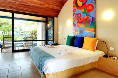 a bedroom with a large bed with a painting on the wall at Alma del Pacifico Hotel & Spa in Esterillos Este