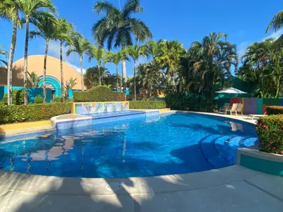 a swimming pool with palm trees in the background at Alma del Pacifico Hotel & Spa in Esterillos Este
