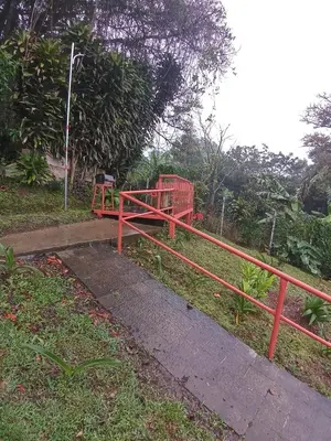 a red bridge with a red railing in a park at Casa entre la naturaleza in San Marcos