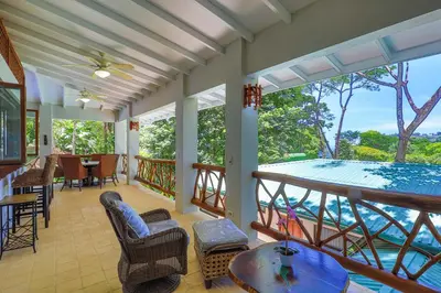a screened in porch with a view of a swimming pool at Casa de Paz- Portasol Vacation Rentals in Matapalo