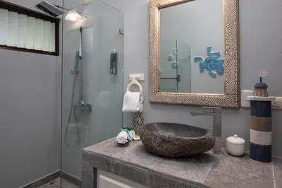 a bathroom with a stone sink and a shower at Casa de Paz- Portasol Vacation Rentals in Matapalo