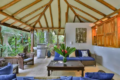 a living room with a blue couch and a table at Casa de Paz- Portasol Vacation Rentals in Matapalo