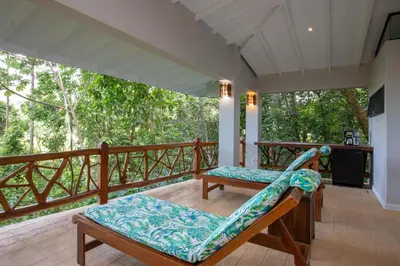 a porch with a bench and a slide at Casa de Paz- Portasol Vacation Rentals in Matapalo
