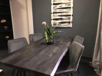 a dining room table with chairs and a vase with flowers at Good Life Lodge in Sámara