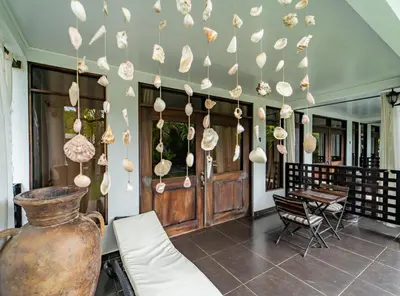 a lobby with a bunch of shells hanging from the ceiling at Good Life Lodge in Sámara