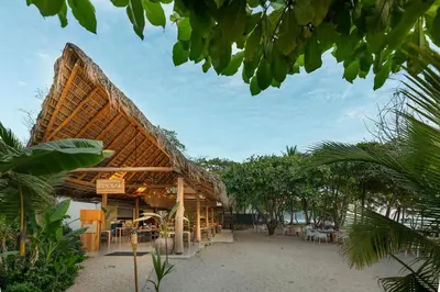a building with a roof on the beach at Hotel Nantipa - A Tico Beach Experience in Santa Teresa Beach