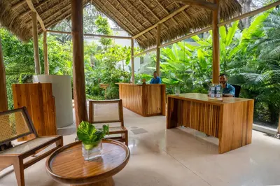two people sitting at a bar in a restaurant at Hotel Nantipa - A Tico Beach Experience in Santa Teresa Beach