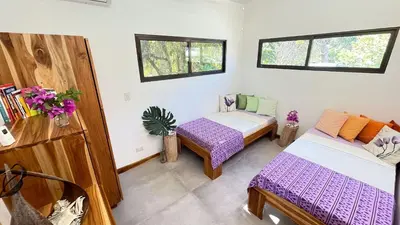 a room with two beds and two windows at Villas Roma Del Mar in Playa Naranjo