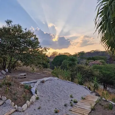 a wooden path in a field with a sunset in the background at Villas Roma Del Mar in Playa Naranjo
