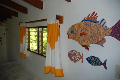 a wall with a painting of a fish on it at Beso del Viento (Adults Only) in Parrita