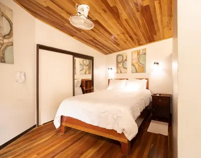 a bedroom with a bed with a wooden ceiling at Gamaí Monteverde Tiny House in Monteverde Costa Rica