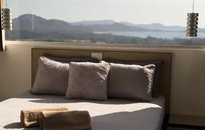 a bed with pillows in front of a window at Horizon Lodge Potrero in Potrero