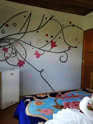 a bedroom with a tree mural on the wall at Casa Copalchi in Monteverde Costa Rica