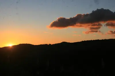 a sunset over a hill with the sun in the sky at Casa Copalchi in Monteverde Costa Rica