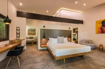 a bedroom with a king sized bed and a desk and a desk at Cala Luna Boutique Hotel & Villas in Tamarindo