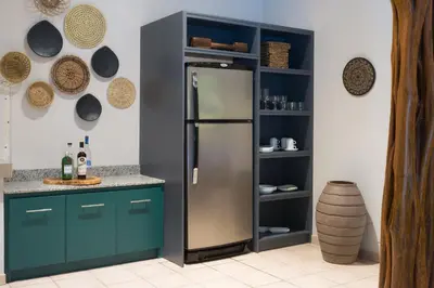 a kitchen with a stainless steel refrigerator and shelves at Cala Luna Boutique Hotel & Villas in Tamarindo