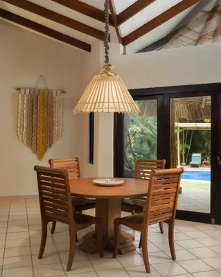 a dining room table with chairs and a chandelier at Cala Luna Boutique Hotel & Villas in Tamarindo